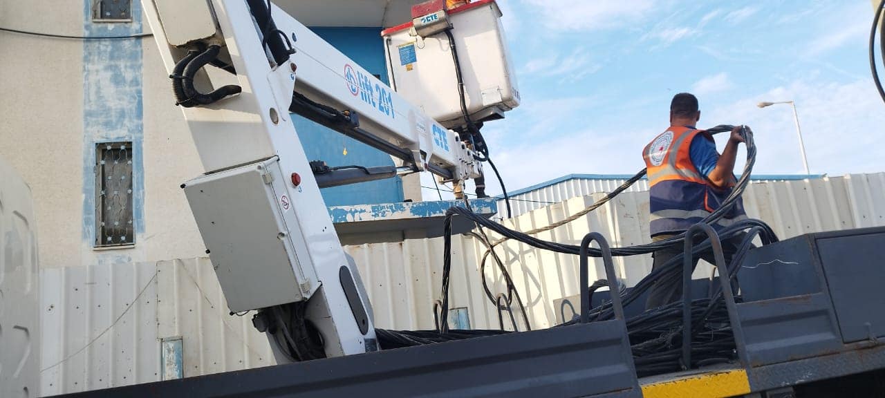 طواقم شركة توزيع كهرباء تقوم بالمساهمة بتوفير وتوصيل كابل 4*95 ABC طول 300 متر في منطقة البصة -دير البلح لزوم تشغيل مضخة صرف صحي البصة .